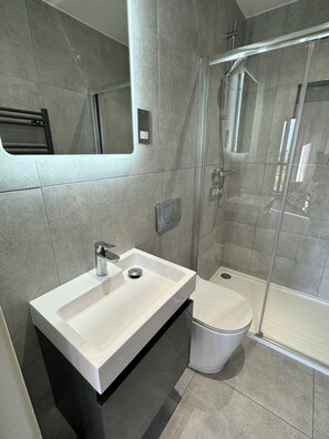 Chuveiro, secador de cabelo, toalhas de banho, sabonete