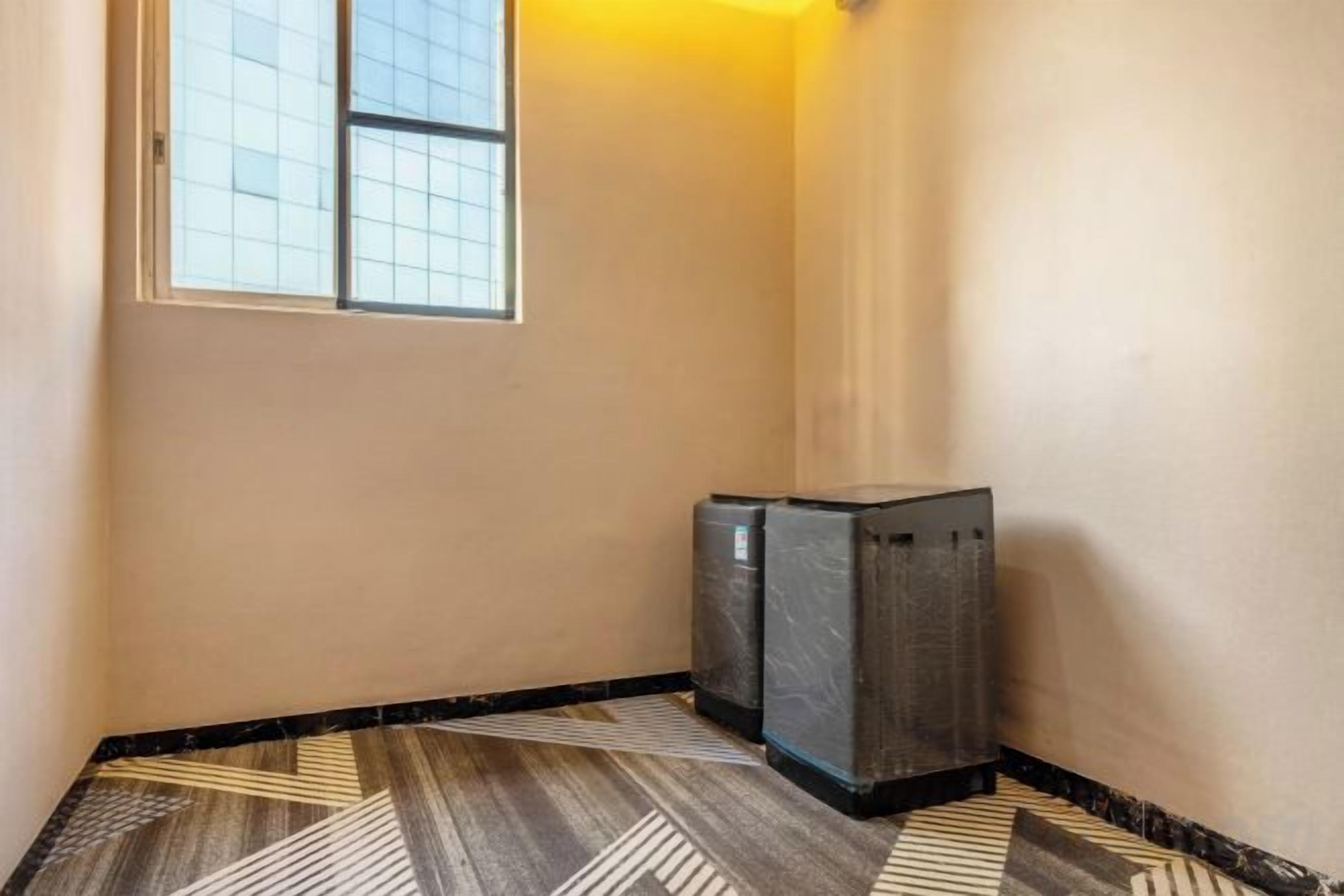 Un pasillo con piso estampado, una ventana y dos unidades de aire acondicionado.