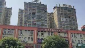 Un edificio de varios pisos con varios establecimientos comerciales en la planta baja.