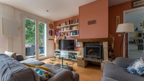 A living room with a fireplace, bookshelves, and a television.