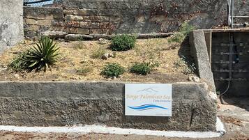 Un mur de pierre sur lequel est apposée une plaque indiquant : « Borgo Palombaio, résidence de vacances en bord de mer, Costa Sarsena ».