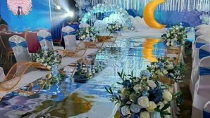 A banquet hall with a long table set for a formal event, decorated with floral arrangements and a reflective floor. - Tianrui Zhongzhou International Hotel (Ruzhou)