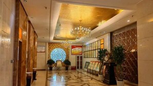 A spacious lobby with a geometric patterned floor, a large circular window, and a chandelier. - Tianrui Zhongzhou International Hotel (Ruzhou)