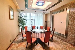 Une salle de conférence équipée d’une table ronde, de chaises et d’un luminaire au plafond.