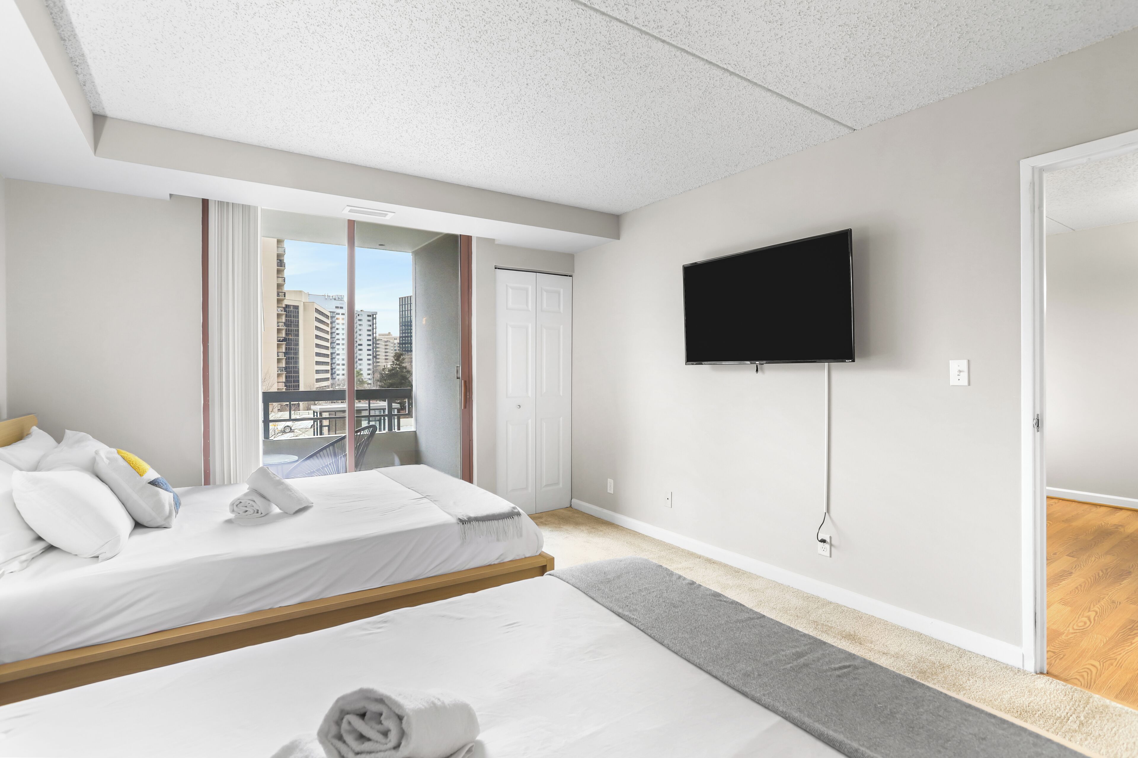 Una habitación de hotel moderna con una cama, un televisor y vistas a la ciudad.