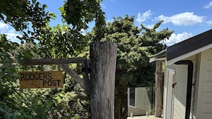 Une terrasse en bois mène à un bâtiment sur lequel est affiché un panneau indiquant « RODGERS POST ».