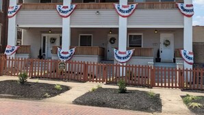A two-story building with a balcony on each floor, a wooden fence in front, and a brick pathway leading to the entrance. - Espresso Maker & Modern Decor by Arena, University, Hospitals (Huntington)