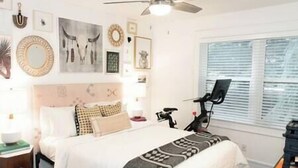 A bedroom with a bed, a ceiling fan, a window with blinds, and various wall decorations. - Park City Condo, Park City Condo In The Heart Of Park City (Park City)