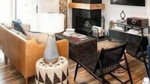 A modern living room with a fireplace, a flat-screen TV mounted on the wall, and a dining area with a table and chairs. - Park City Condo, Park City Condo In The Heart Of Park City (Park City)