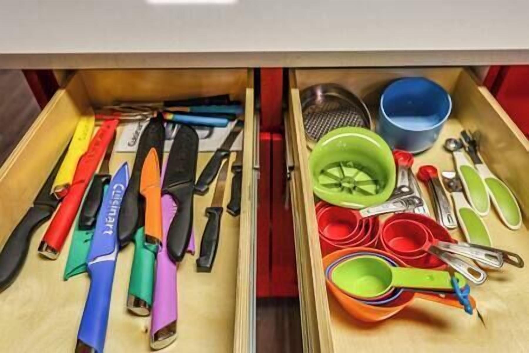 A drawer containing various kitchen utensils and measuring tools.