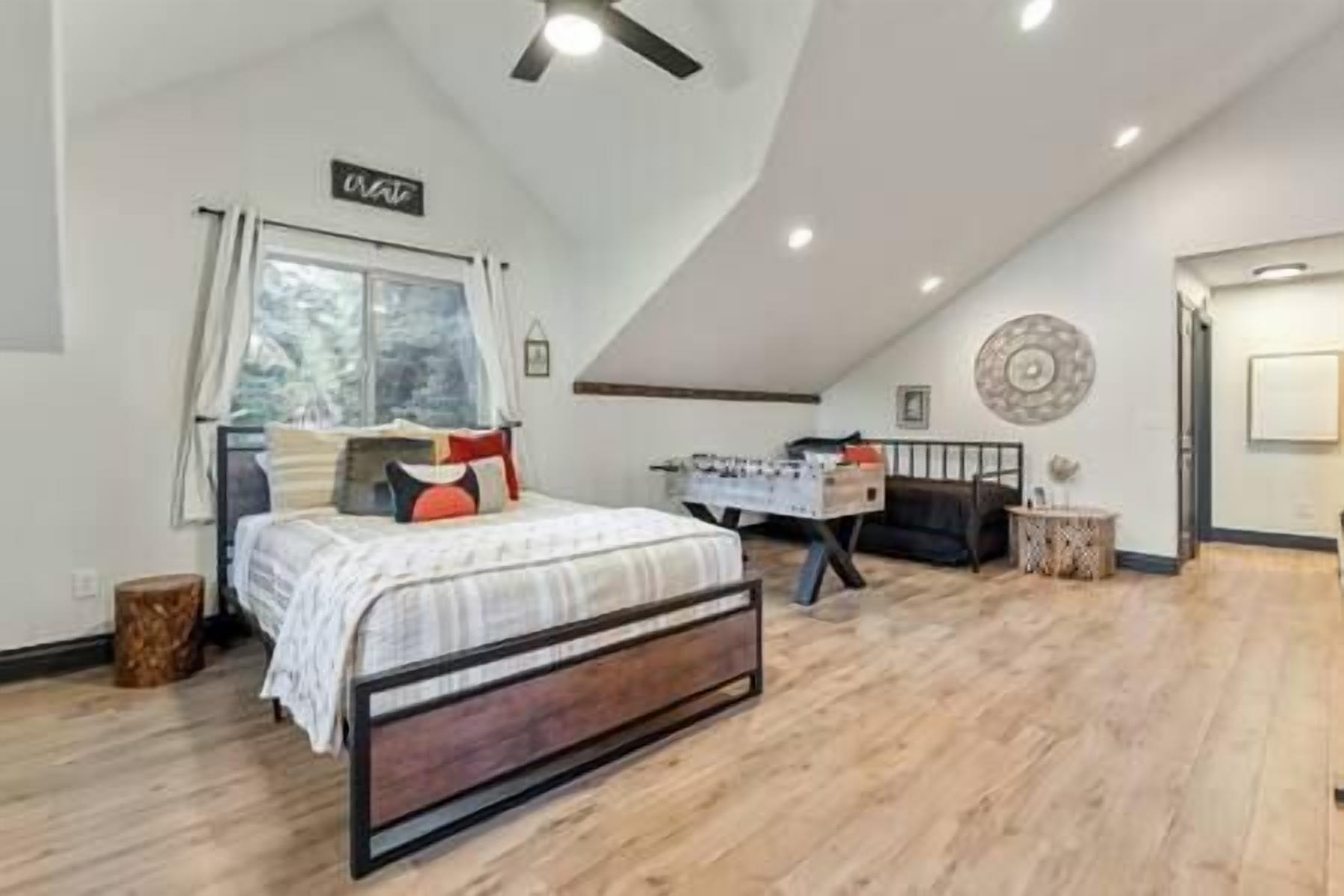 Un dormitorio con una cama, un escritorio y una ventana.