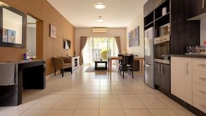 A modern kitchen with a dining area, a coffee machine, and a refrigerator. - Apartments 125 (Gaborone)