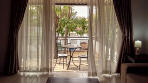 A room with a view to a balcony, featuring a table and chairs. - Apartments 125 (Gaborone)