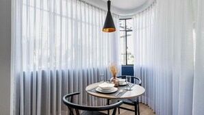 A dining area with a round table, black chairs, and a hanging light fixture. - Blueground Oaxaca CDMX (Mexico City)