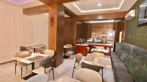 A restaurant with tables and chairs, a counter, and a sofa. - Jukky Hotel (Abuja)