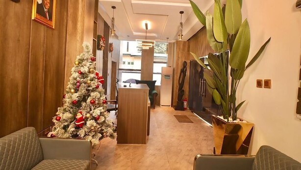 A hotel lobby with a Christmas tree, seating area, and a reception desk. - Jukky Hotel (Abuja)