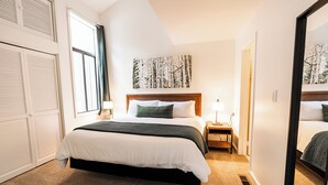 A hotel room with a large bed, a nightstand, a mirror, and a window with curtains. - Tranquil 2-bedroom condo in Park City-Clubhouse pool/hot tub, free bus to resort (Park City)