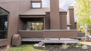 A modern house with a large window, a small skylight, and a wooden deck. - Tranquil 2-bedroom condo in Park City-Clubhouse pool/hot tub, free bus to resort (Park City)