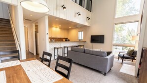 A spacious living area with a dining table, sofa, and kitchen in the background. - Tranquil 2-bedroom condo in Park City-Clubhouse pool/hot tub, free bus to resort (Park City)