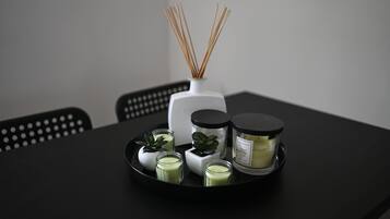 Una bandeja con diversas velas aromáticas y difusores de aroma en una mesa negra.