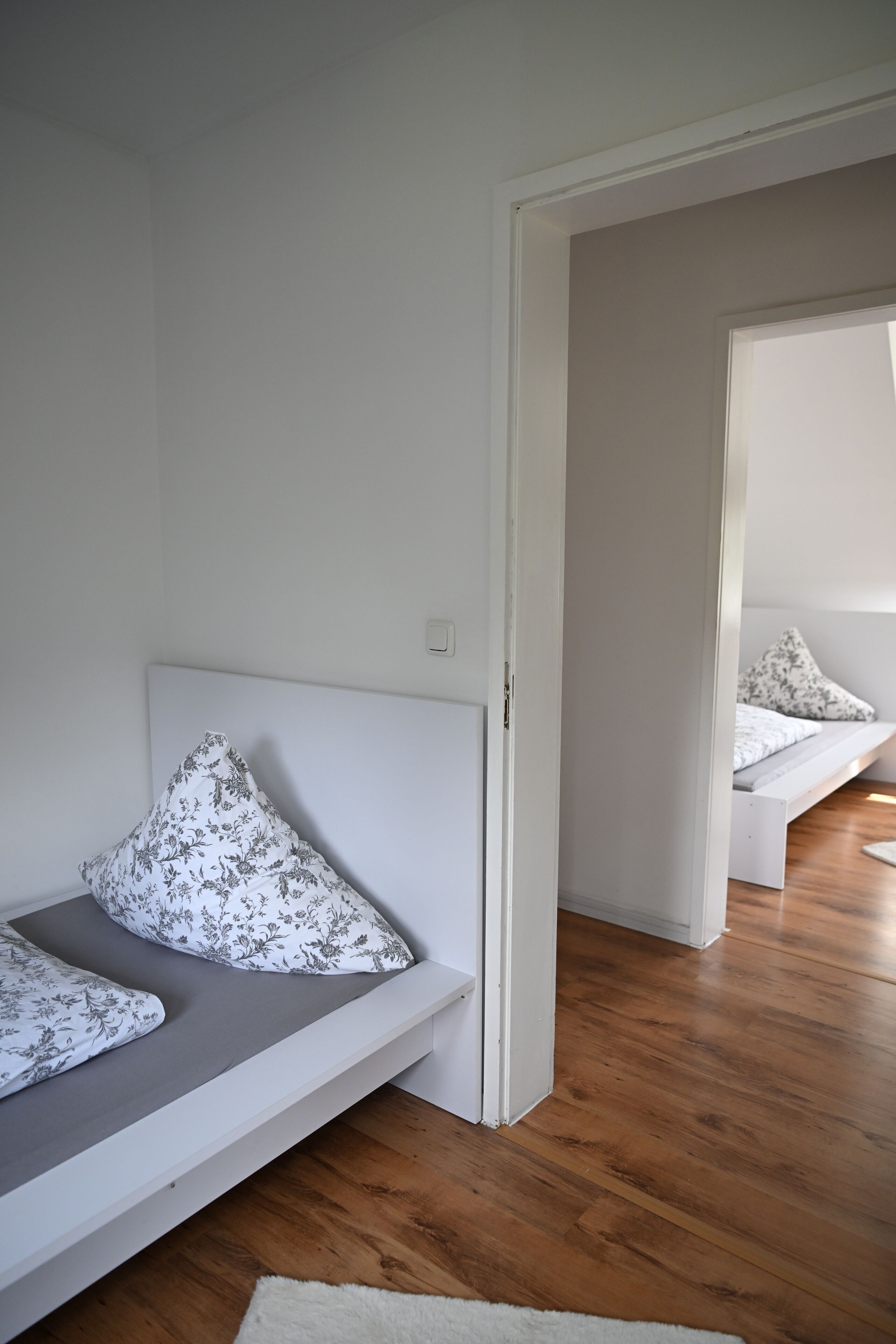 Una habitación moderna y minimalista con un banco integrado y suelo de madera.