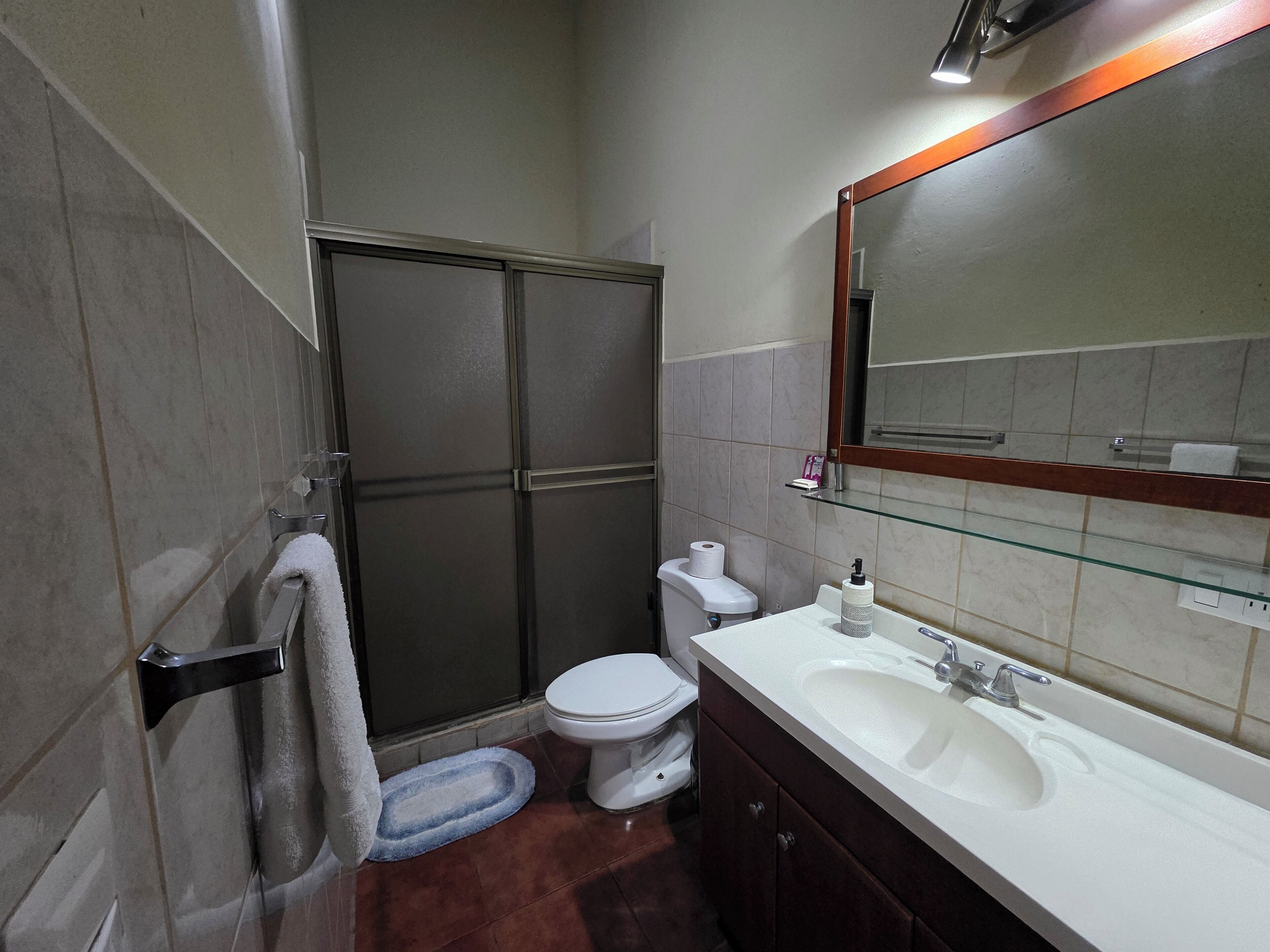A bathroom with a shower, toilet, and sink.