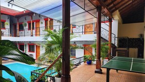 A multi-level building with a pool, outdoor seating, and a ping pong table. - Casona Macondo (Granada)