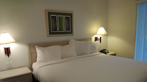 A neatly made bed with white linens, a wooden headboard, and two bedside lamps. - Adorable Townhouse at Magic Resort no fees-1064 (Kissimmee)
