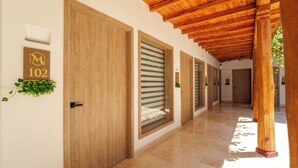 Pasillo con puertas de madera y un cartel de números, que conduce a habitaciones.