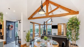 A modern kitchen with a large island, wooden beams, and a fireplace. - 1 bedroom accommodation in Llangollen (Llangollen)