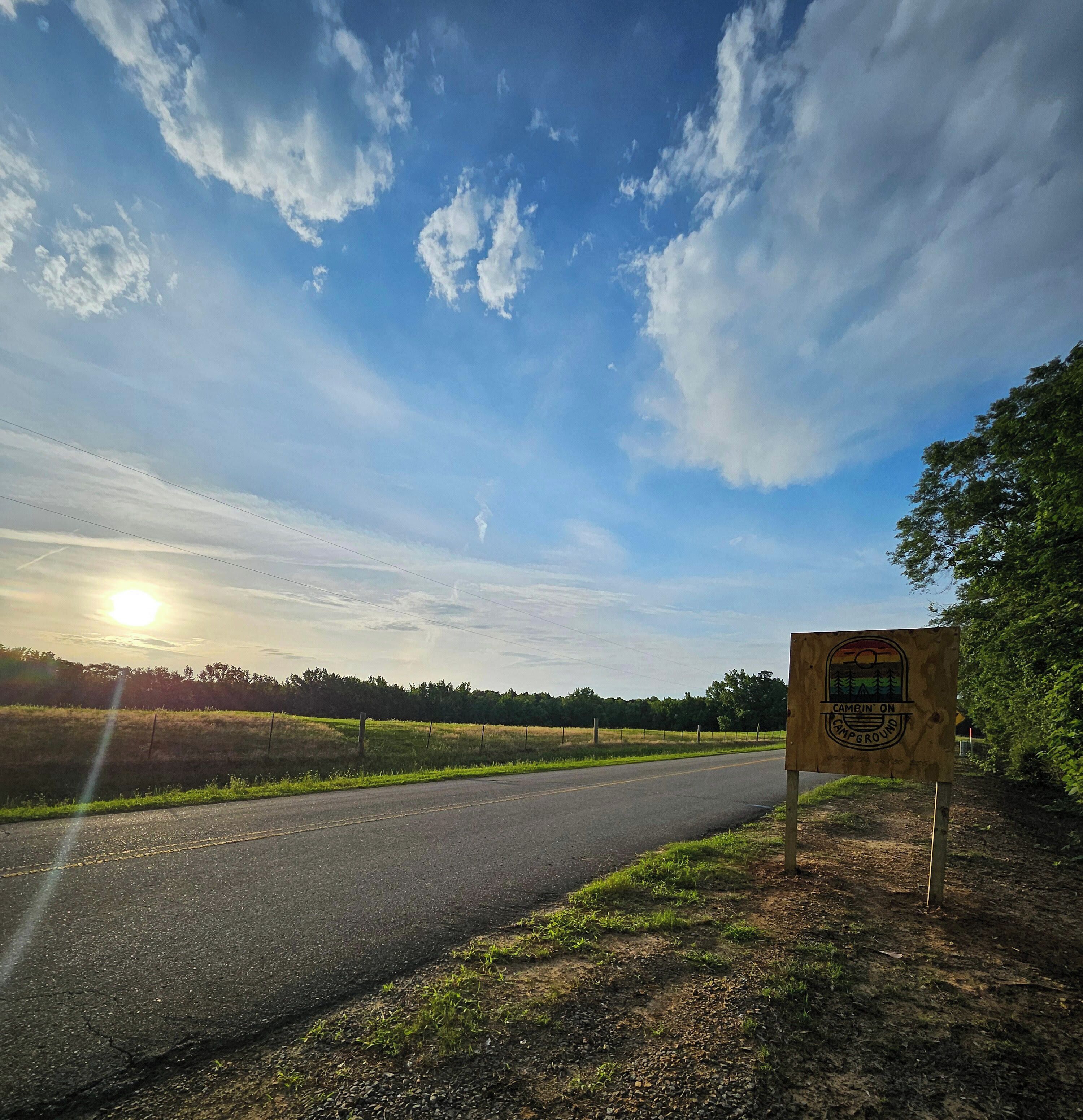 A road with a sign indicating a campground.