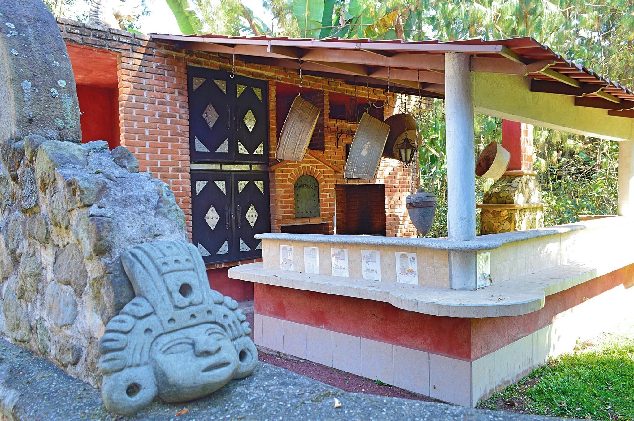 A traditional building with a brick facade, a black decorative door, and a stone sculpture.