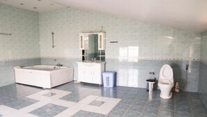 A bathroom with a bathtub, a toilet, a sink, and a mirror. - Premier Villas (Baku)