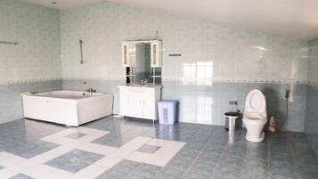A bathroom with a bathtub, a toilet, a sink, and a mirror.