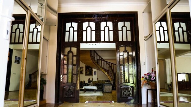 A grand entrance with a wooden staircase leading to a second floor. - Premier Villas (Baku)