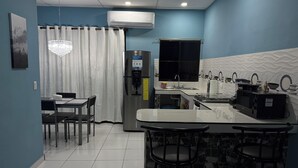 A modern kitchen with a refrigerator, stove, and bar area.
