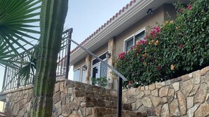 Una escalera de piedra que conduce a una casa con techo de tejas y un pequeño balcón.