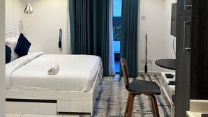 A modern hotel room with a bed, a desk, a chair, and a TV. - Unwind in Style at your luxurious Retreat in the Heart of Cantonments (Accra)