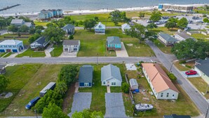 Zona residencial costera con casas, una playa y un muelle.