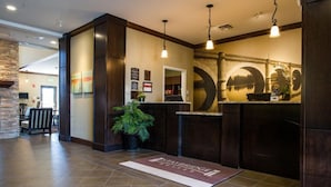 A reception area with a stone wall, a reception desk, and a large mural. - King Suite, Breakfast, Pool, Near Univ of Nebraska (Lincoln)