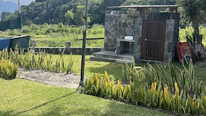 Un edificio de piedra con puerta de madera, un pequeño porche y un lavamanos.