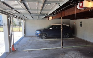 A parking garage with a blue SUV parked inside.