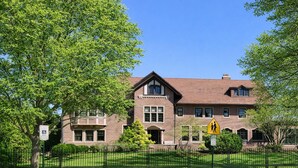 A two-story building with a brick facade, a visible entrance, and a pedestrian crossing sign. - The Oak Park Loft, Including Garage (Oak Park)