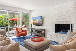 TV connectée, cheminée, livres, chaîne hi-fi