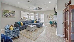 Un salon spacieux avec un canapé d’angle, une table basse et un tapis à motifs.