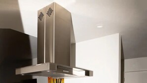 Cuina moderna amb forn integrat, microones i campana extractora d'acer inoxidable.