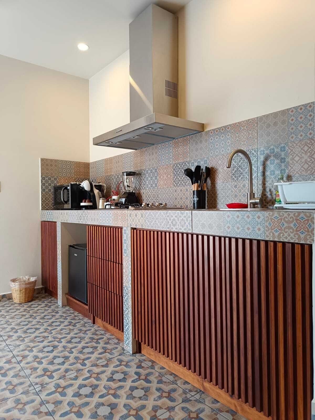 A modern kitchen with a patterned backsplash, a built-in stove, and a microwave.