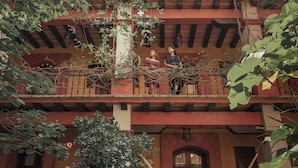 A two-story building with a balcony on the upper floor. - Suites Amanecer by Casa del Sótano (Oaxaca)