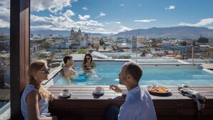 A rooftop pool area with a view of a cityscape and mountains. - Suites Amanecer by Casa del Sótano (Oaxaca)