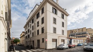 A multi-story building with a flat facade, large windows, and a street view. - GuestHost - Modern and bright apartment of 60 sqm, able to accommodate up to 2 people, located on the second floor of a building without a lift (NOT suitable for disabled people).The property is located in an area well connected by public transport, just (Roma)